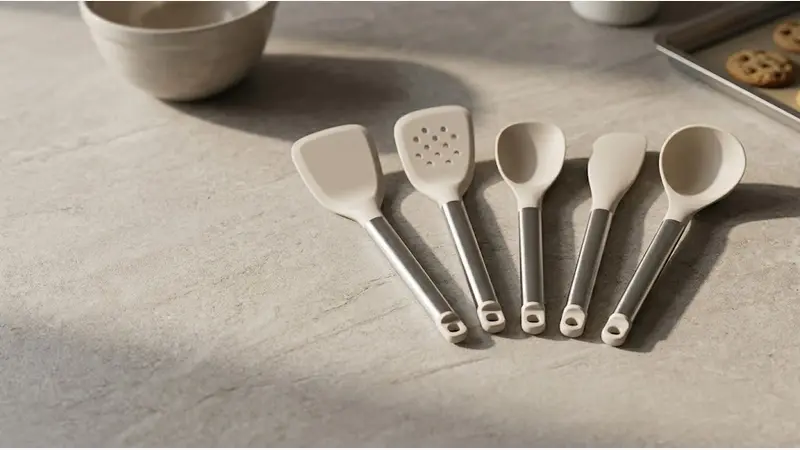 A coordinated range of silicone spatulas for baking and cooking, displayed in a modern retail-ready kitchen setting.