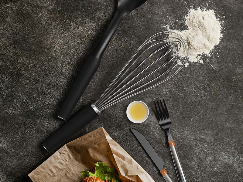 L-TOOLS baking utensils and flour arranged on a kitchen counter, ready for cooking preparation.