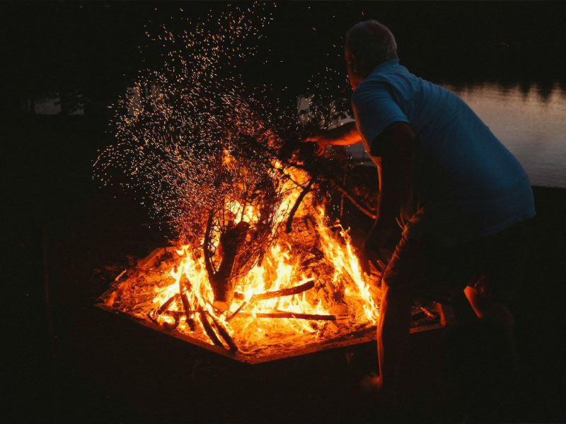 L-TOOLS camping bonfire creating a cozy outdoor cooking and social experience.