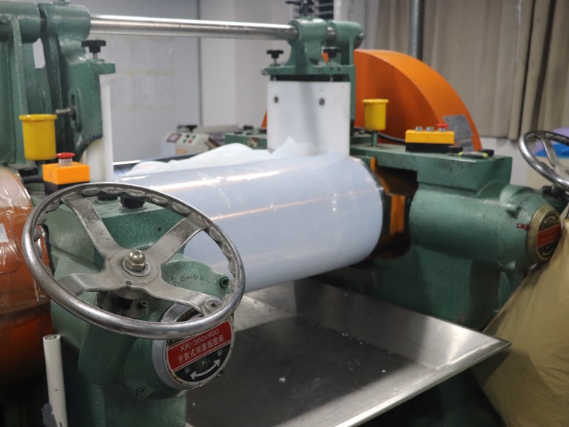 L-TOOLS industrial machine with rollers processing material, showcasing manufacturing efficiency.