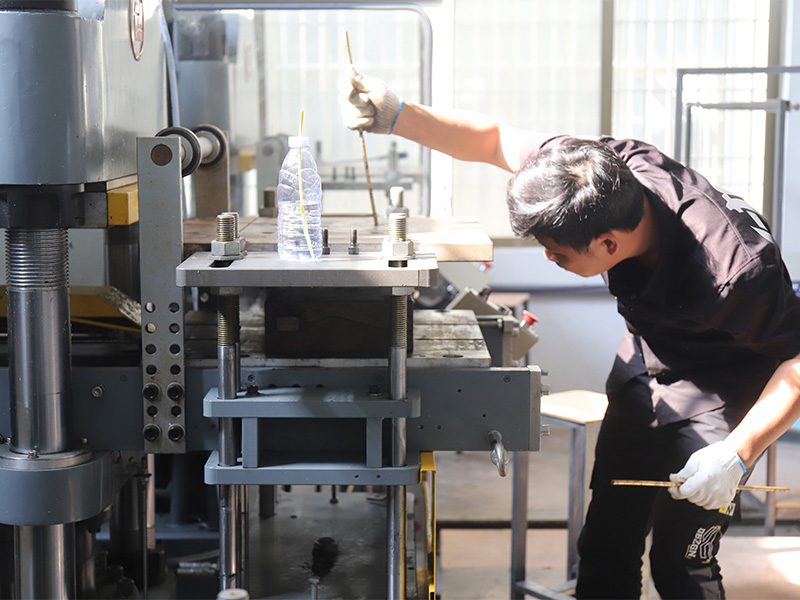 L-TOOLS employee adjusting industrial equipment, illustrating meticulous factory workflow.