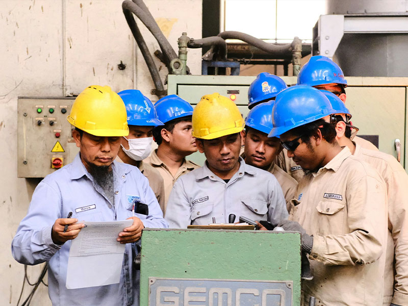 L-TOOLS team of engineers and workers wearing hard hats reviewing a project on-site.