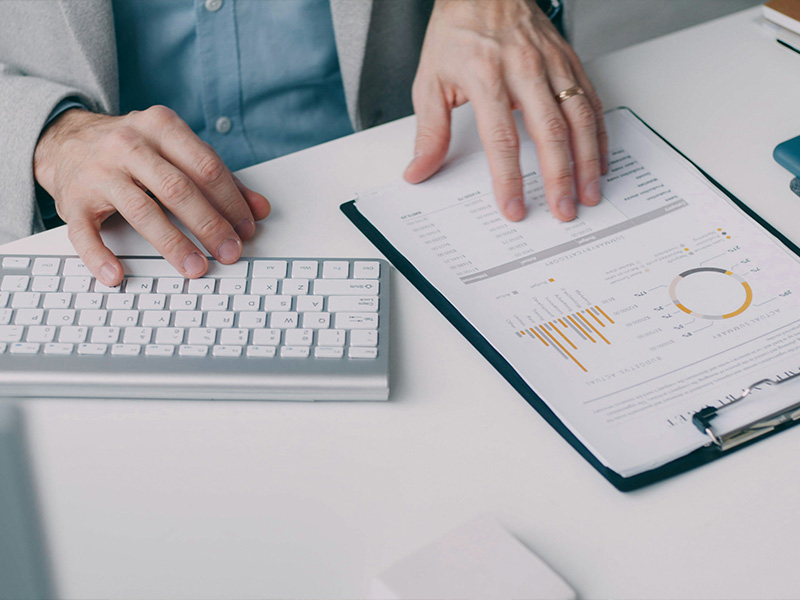 L-TOOLS hands calculating and marking documents, emphasizing precise office work and planning.