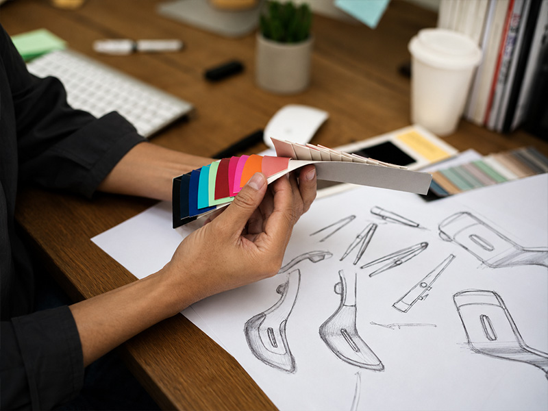 L-TOOLS product design team reviewing sketches and color samples during a kitchenware development project.