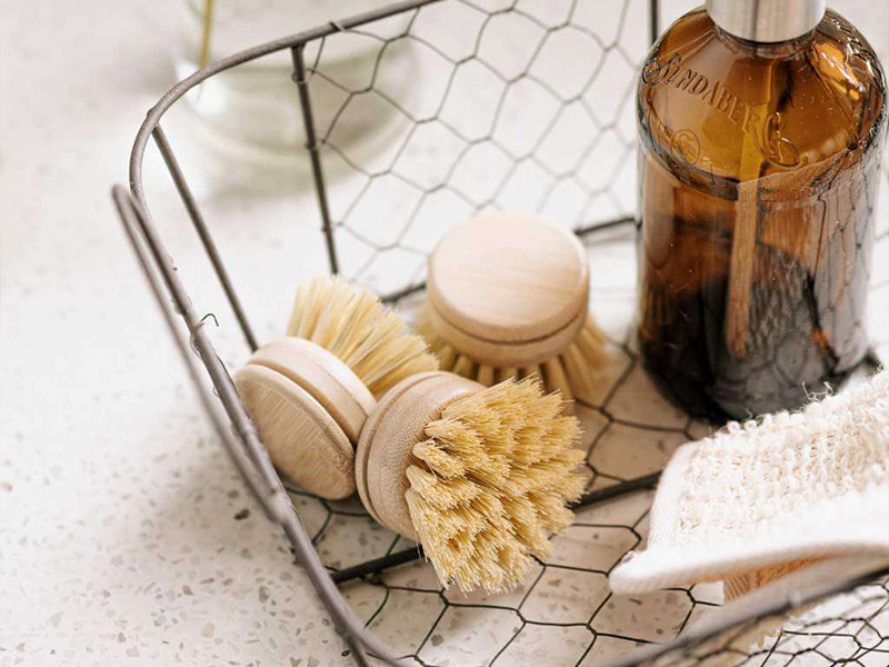 L-TOOLS basket of natural fiber brushes with wooden handles, emphasizing sustainable household products.
