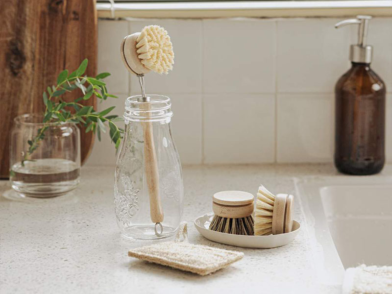 L-TOOLS eco-friendly kitchen brushes and utensils arranged on a counter, highlighting sustainable cleaning tools.