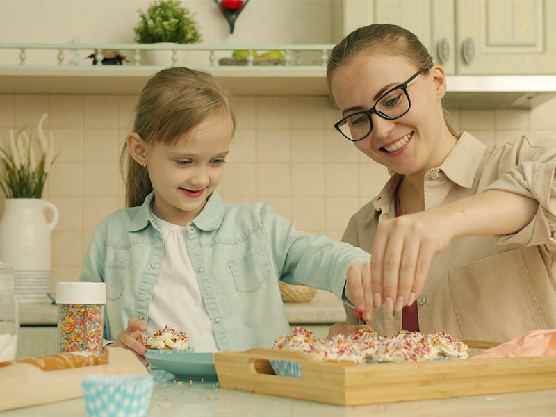 L-TOOLS children and adults enjoying family baking activity, making dough shapes together in the kitchen.