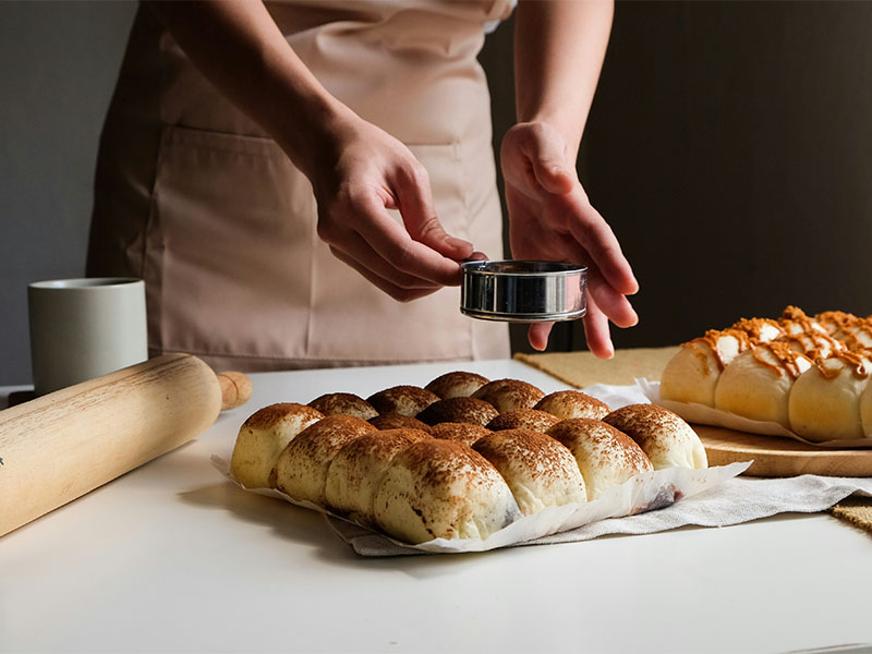 L-TOOLS person arranging cookie dough shapes on a baking tray, showcasing organized preparation.