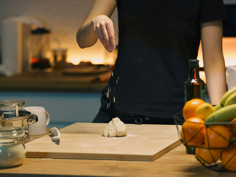 L-TOOLS hand mixing dough in a bowl, highlighting active home cooking and baking process.
