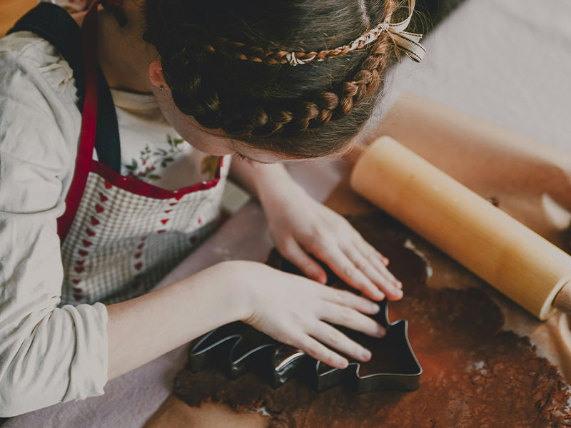 L-TOOLS child rolling dough with a rolling pin, demonstrating hands-on baking activity.