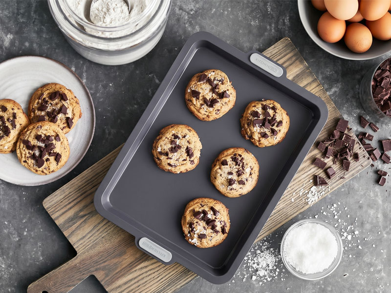 L-TOOLS family decorating and cutting cookie shapes together, highlighting creative baking experiences.