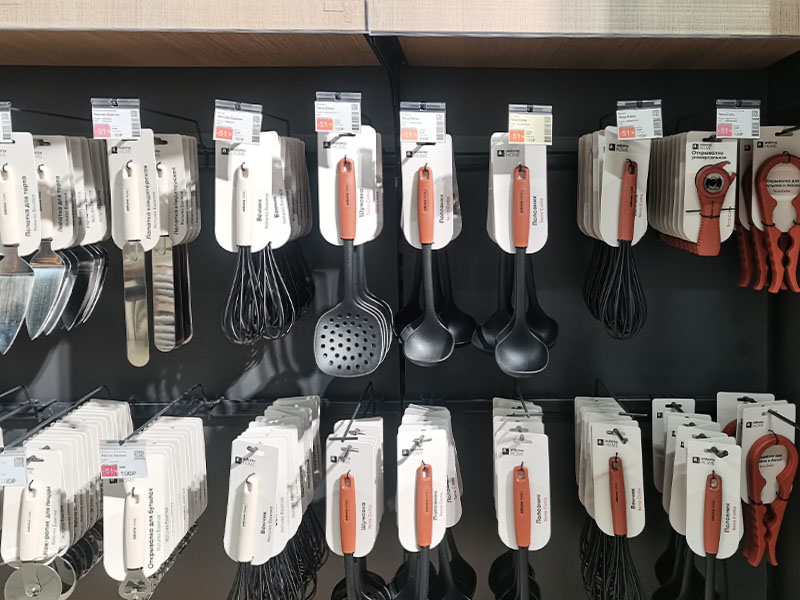 L-TOOLS retail display of kitchen utensils and silicone cooking tools, emphasizing organized store presentation.
