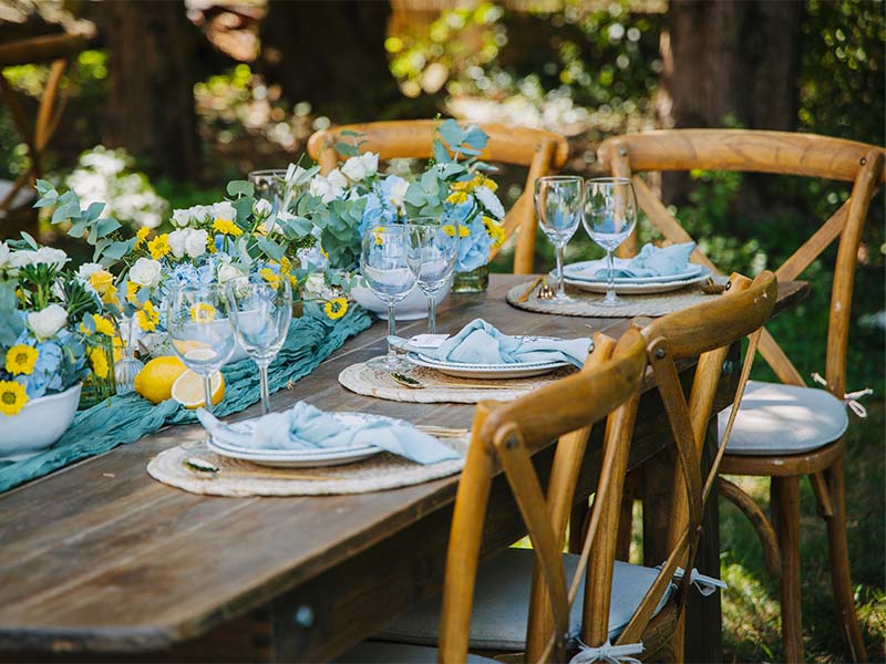L-TOOLS outdoor table decorated with flowers and cutlery, creating a festive and inviting atmosphere.